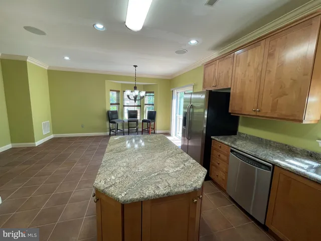 a kitchen with granite countertop sink and refrigerator