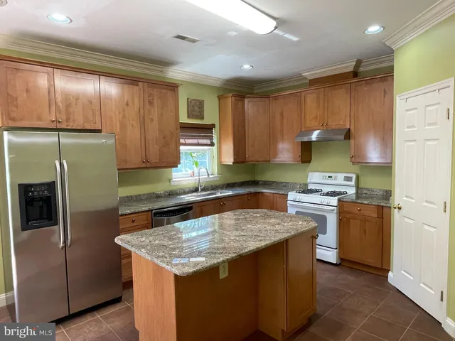 a kitchen with stainless steel appliances granite countertop a stove a refrigerator a sink and dishwasher