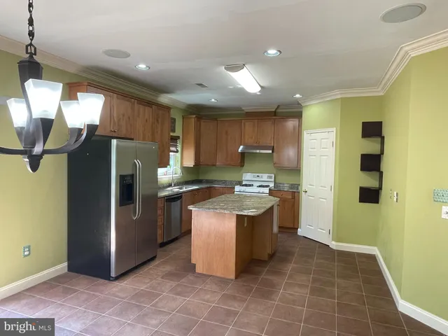 a kitchen with stainless steel appliances granite countertop a refrigerator a sink a stove and island