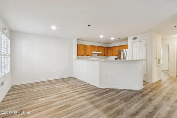 a view of a kitchen with wooden floor and a window