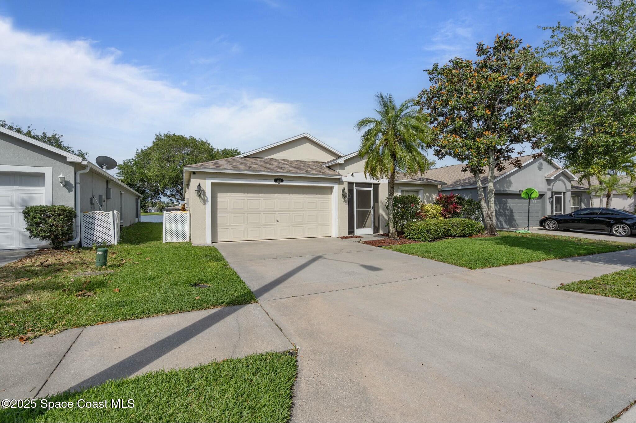 2405 Bayhill Drive Melbourne, FL 32940 - Photo 32 of 36 a front view of a house with a yard and garage