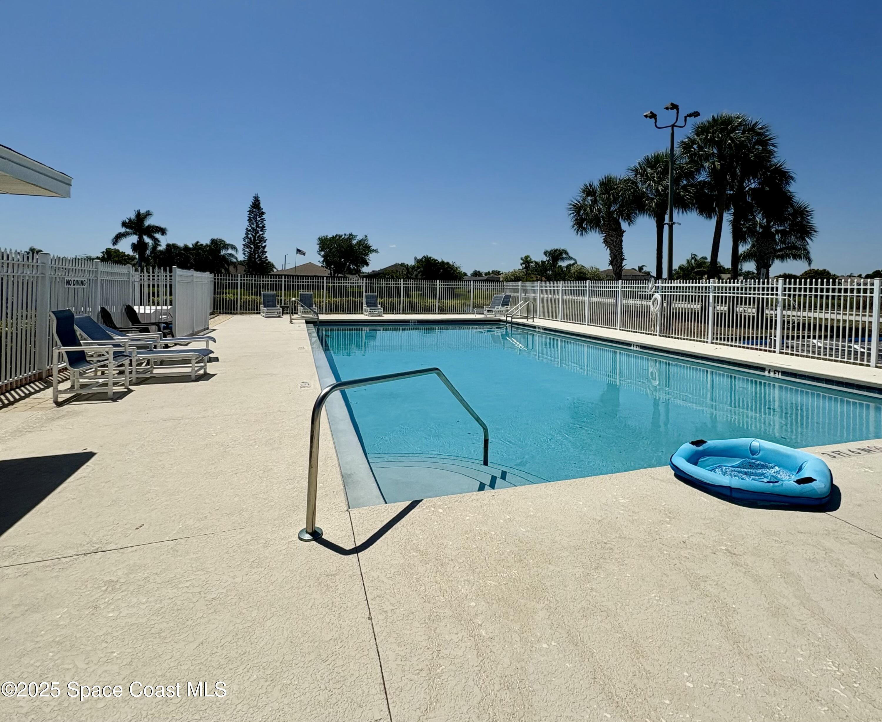 2405 Bayhill Drive Melbourne, FL 32940 - Photo 34 of 36 a view of a swimming pool with a chair and tables