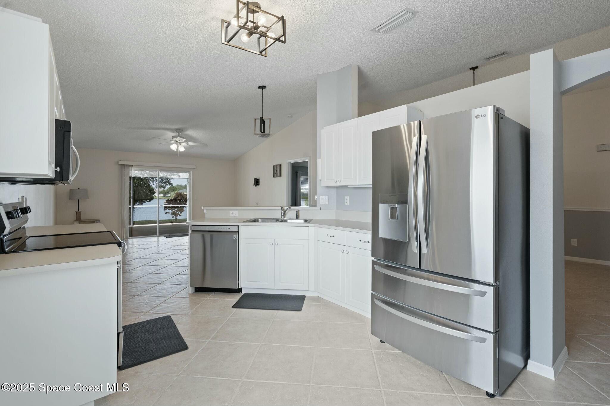 2405 Bayhill Drive Melbourne, FL 32940 - Photo 5 of 36 a kitchen with a refrigerator sink and cabinets
