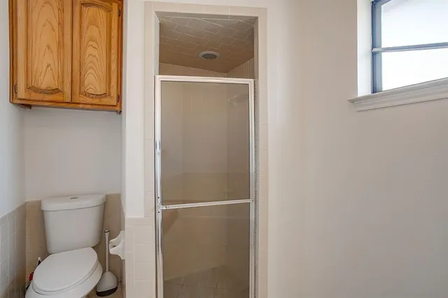 a white toilet sitting next to a window