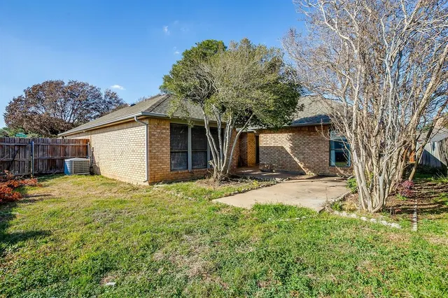 a view of a house with backyard and trees