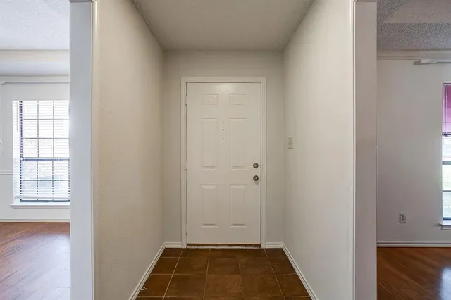 an empty room with wooden floor and window