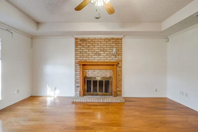 a view of an empty room with window and fire place