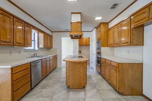 a kitchen with stainless steel appliances granite countertop wooden cabinets a sink and dishwasher
