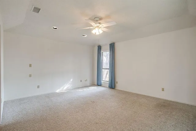 a view of an empty room with a ceiling fan