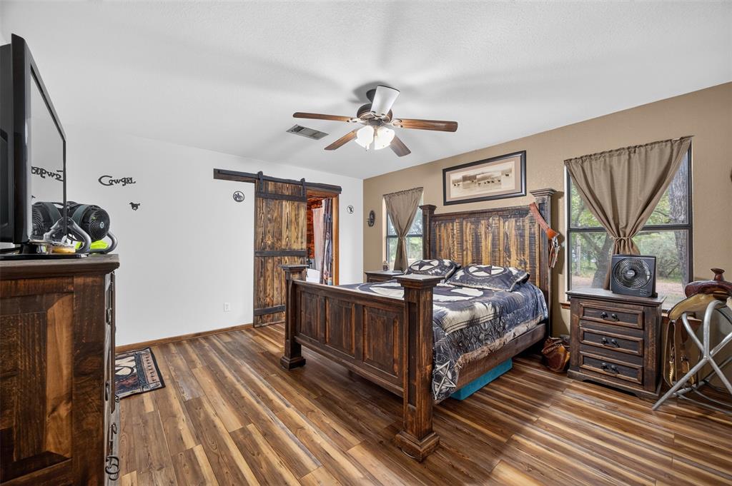 10964 River Ranch Road Kemp, TX 75143 - Photo 23 of 40 Wood-finish flooring throughout, ceiling fan with integrated lighting, and a barn door entry