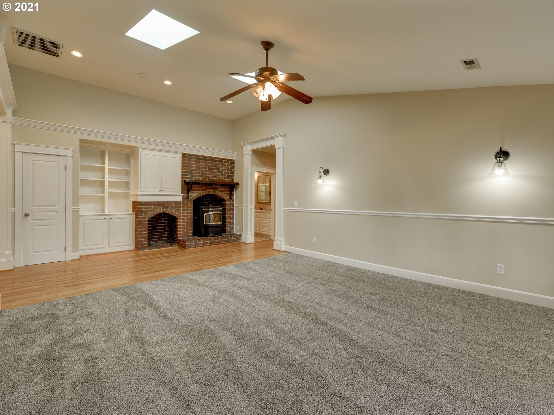 5171 South Elliott Prairie Road Woodburn, OR 97071 - Photo 10 of 32 an empty room with fireplace and wooden floor