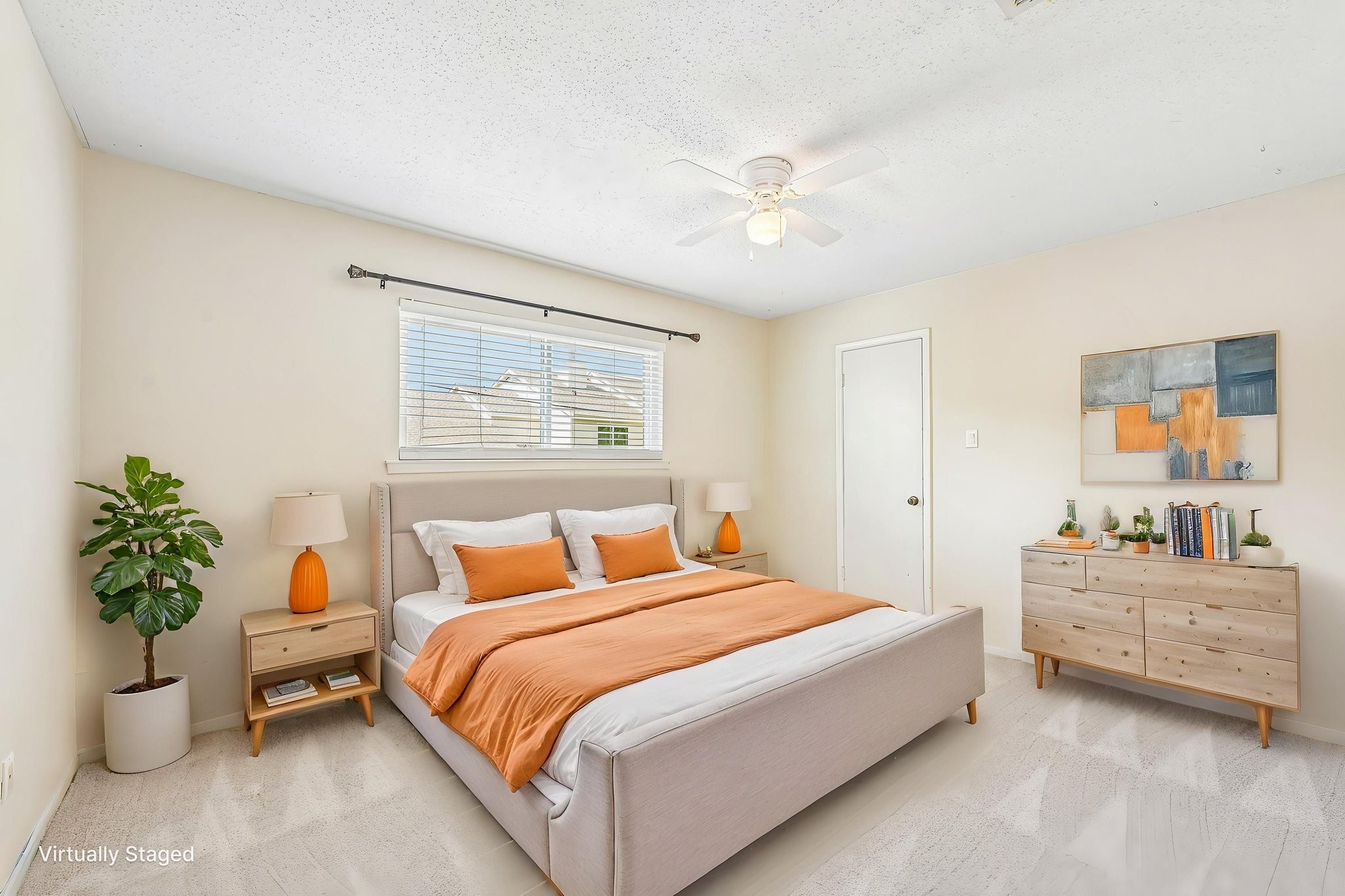 8 Arlington Street Conroe, TX 77301 - Photo 5 of 37 Bedroom #2 upstairs features neutral walls, a large window, and a ceiling fan. It includes a double bed with orange accents, a bedside table, and a dresser, creating a warm and inviting atmosphere.