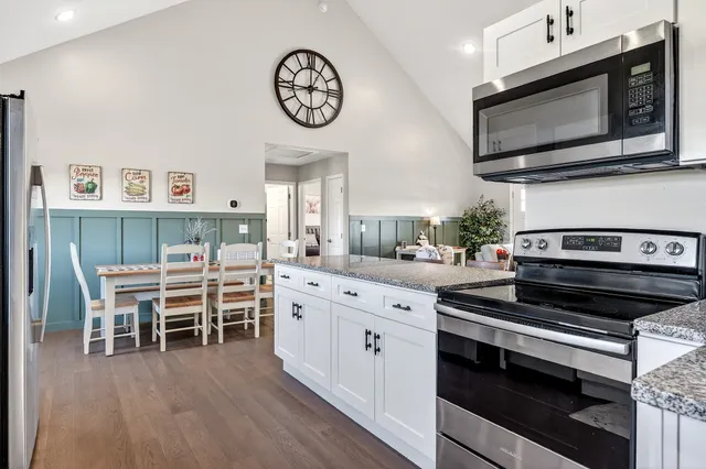 a kitchen with stainless steel appliances a stove a microwave and furniture