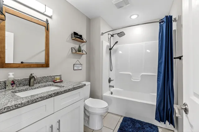 a bathroom with a granite countertop sink toilet and shower