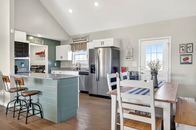 a kitchen with refrigerator and chairs