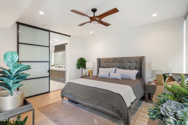 a spacious bedroom with a large bed and a potted plant