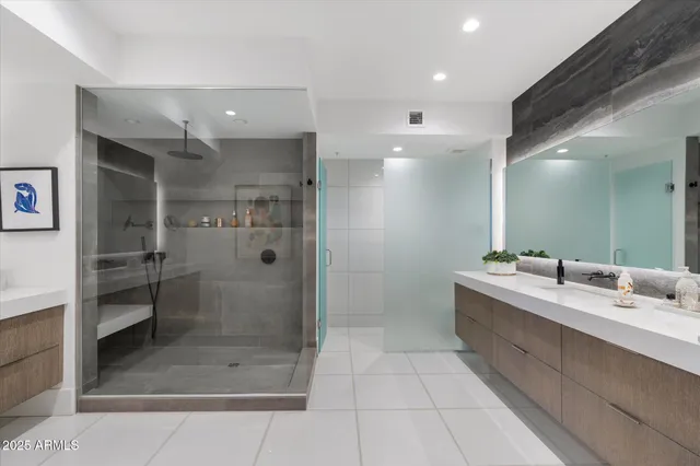 a bathroom with a double vanity sink mirror and shower