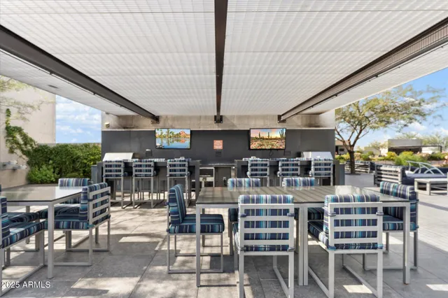 a view of a patio with table and chairs and a large tree