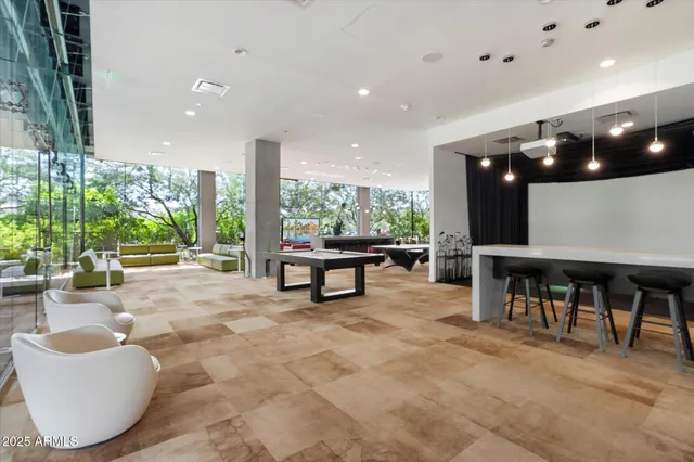 a living room with furniture a table and kitchen view