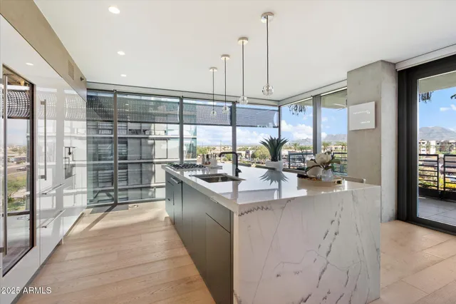 a kitchen with stainless steel appliances granite countertop a sink and a wooden floor