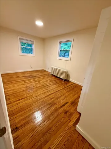 a view of a room with wooden floor and window
