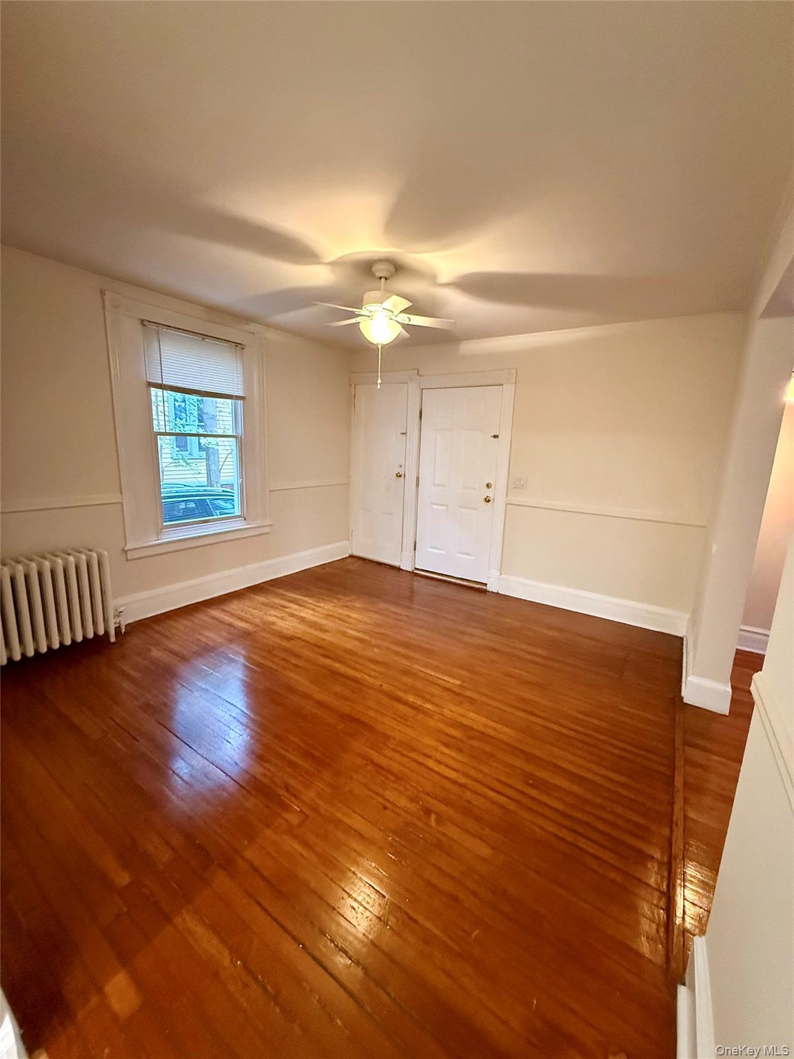 80 Teller Avenue, Unit 1 Beacon, NY 12508 - Photo 4 of 19 an empty room with wooden floor and windows