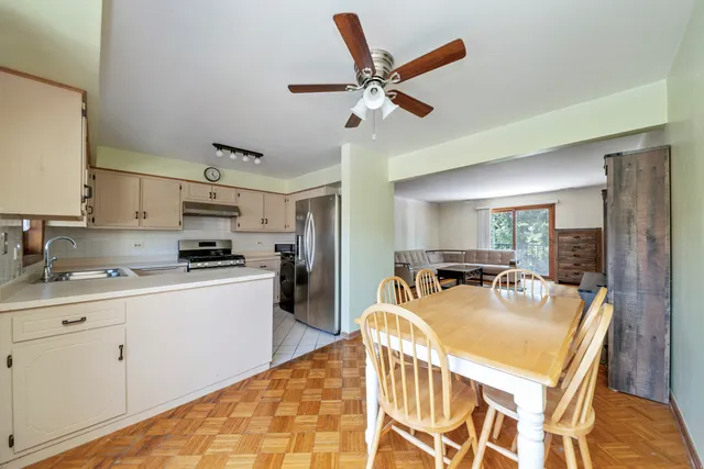 a kitchen with stainless steel appliances granite countertop a stove a sink dishwasher and a refrigerator with wooden floor