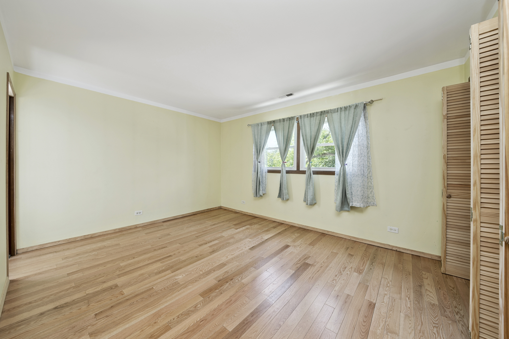 3207 North Pontiac Avenue, Unit 2S Chicago, IL 60634 - Photo 7 of 13 wooden floor in an empty room with a window