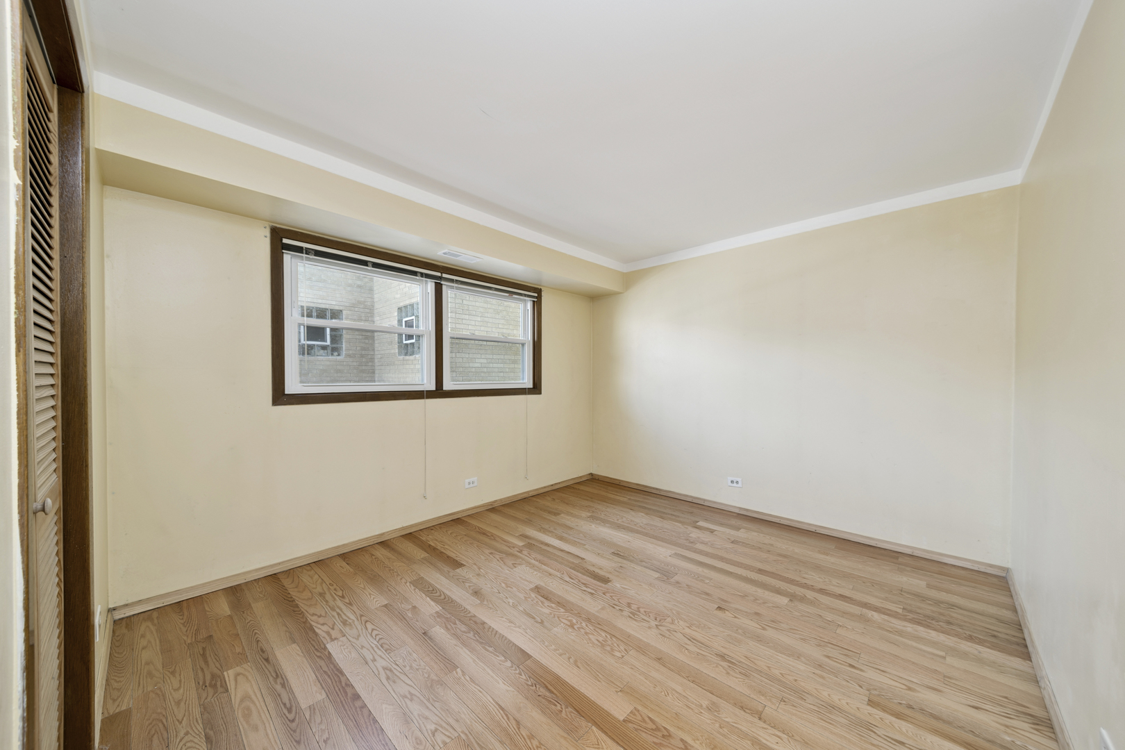 3207 North Pontiac Avenue, Unit 2S Chicago, IL 60634 - Photo 10 of 13 an empty room with wooden floor and windows