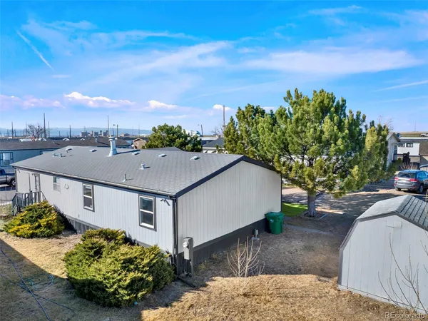 a aerial view of a house with large trees and plants in front of it