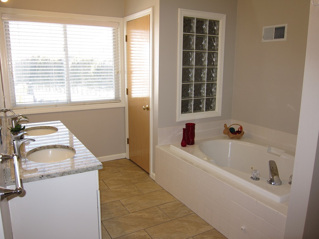 69 Half Crown Circle, Unit 69 Ashland, MA 01721 - Photo 14 of 25 a bathroom with a tub sink and mirror