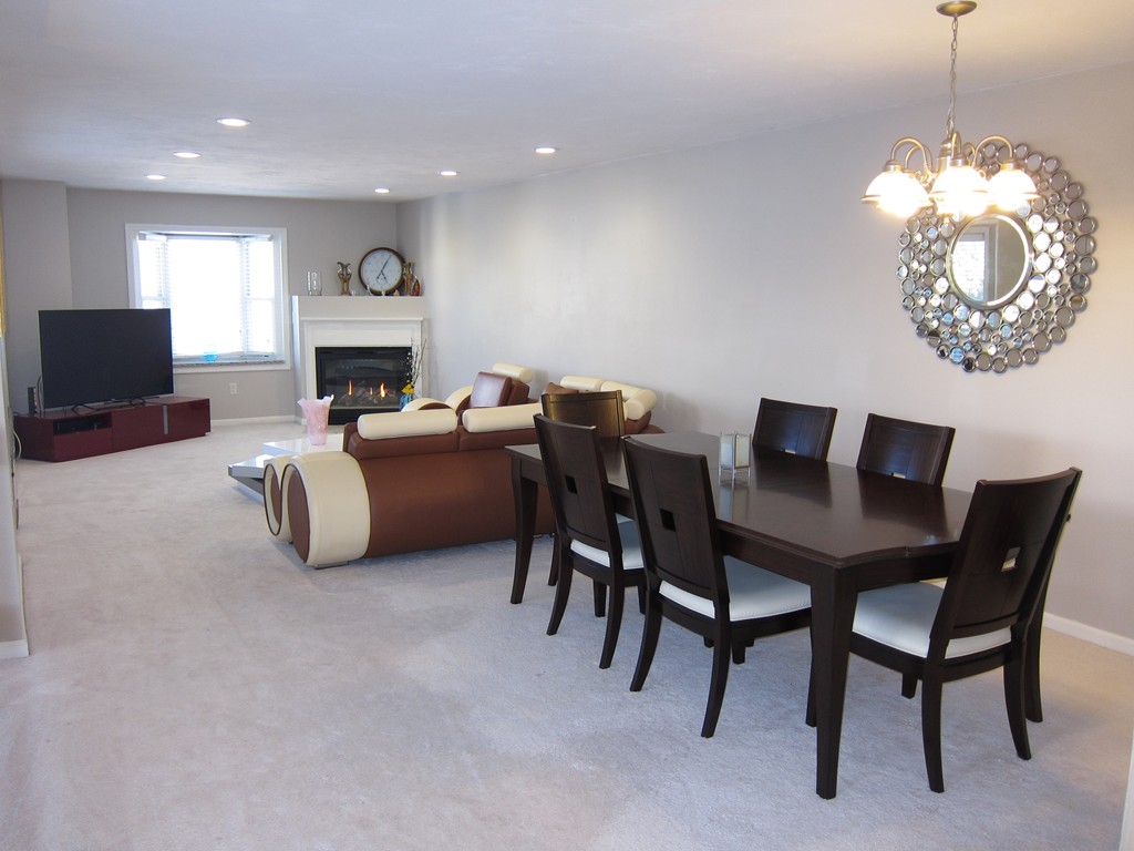 69 Half Crown Circle, Unit 69 Ashland, MA 01721 - Photo 2 of 25 a living room with furniture a fireplace and a table