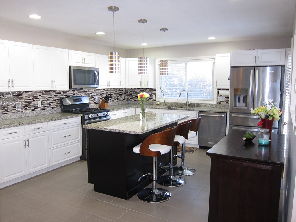 69 Half Crown Circle, Unit 69 Ashland, MA 01721 - Photo 5 of 25 a kitchen with stainless steel appliances granite countertop a refrigerator a sink dishwasher a stove and a dining table with wooden floor