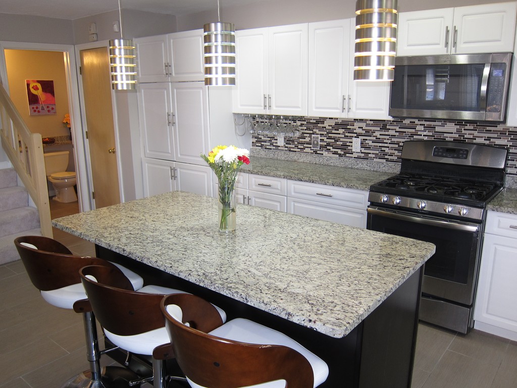 69 Half Crown Circle, Unit 69 Ashland, MA 01721 - Photo 7 of 25 a kitchen with a table chairs and stove