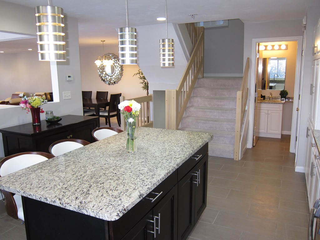 69 Half Crown Circle, Unit 69 Ashland, MA 01721 - Photo 8 of 25 a bathroom with a granite countertop sink a mirror and a wooden floor