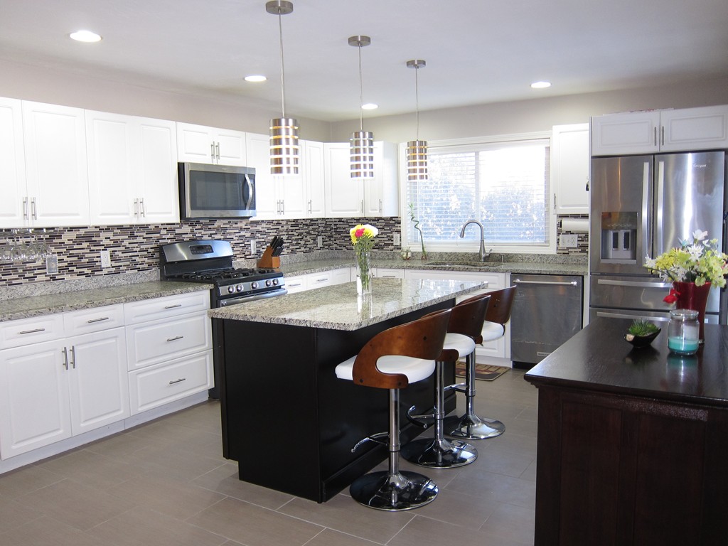 69 Half Crown Circle, Unit 69 Ashland, MA 01721 - Photo 9 of 25 a kitchen with stainless steel appliances granite countertop a stove a sink a microwave a dining table and chairs