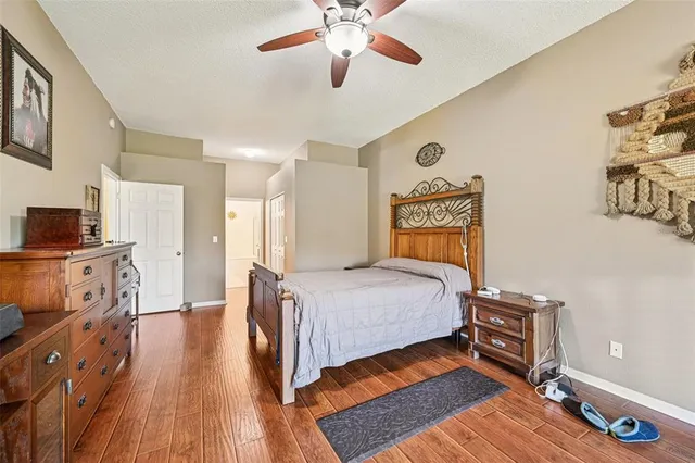 a bedroom with a bed and a dresser with wooden floor