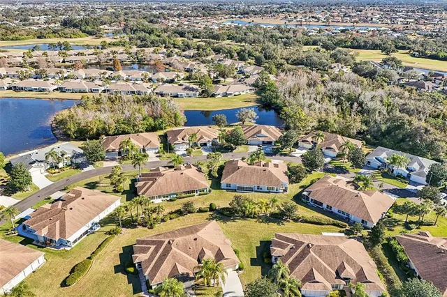 an aerial view of a residential houses with outdoor space and trees