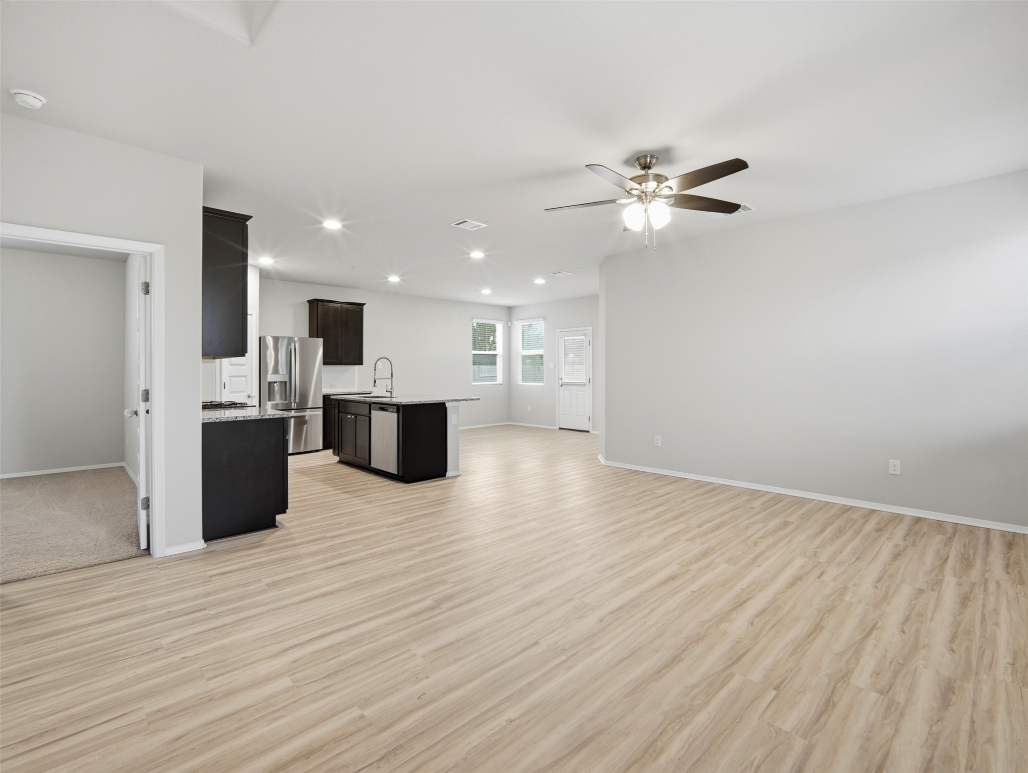 60 Bent Trl Lane Georgetown, TX 78628 - Photo 6 of 40 An open-concept living space with a contemporary kitchen and light wood flooring.