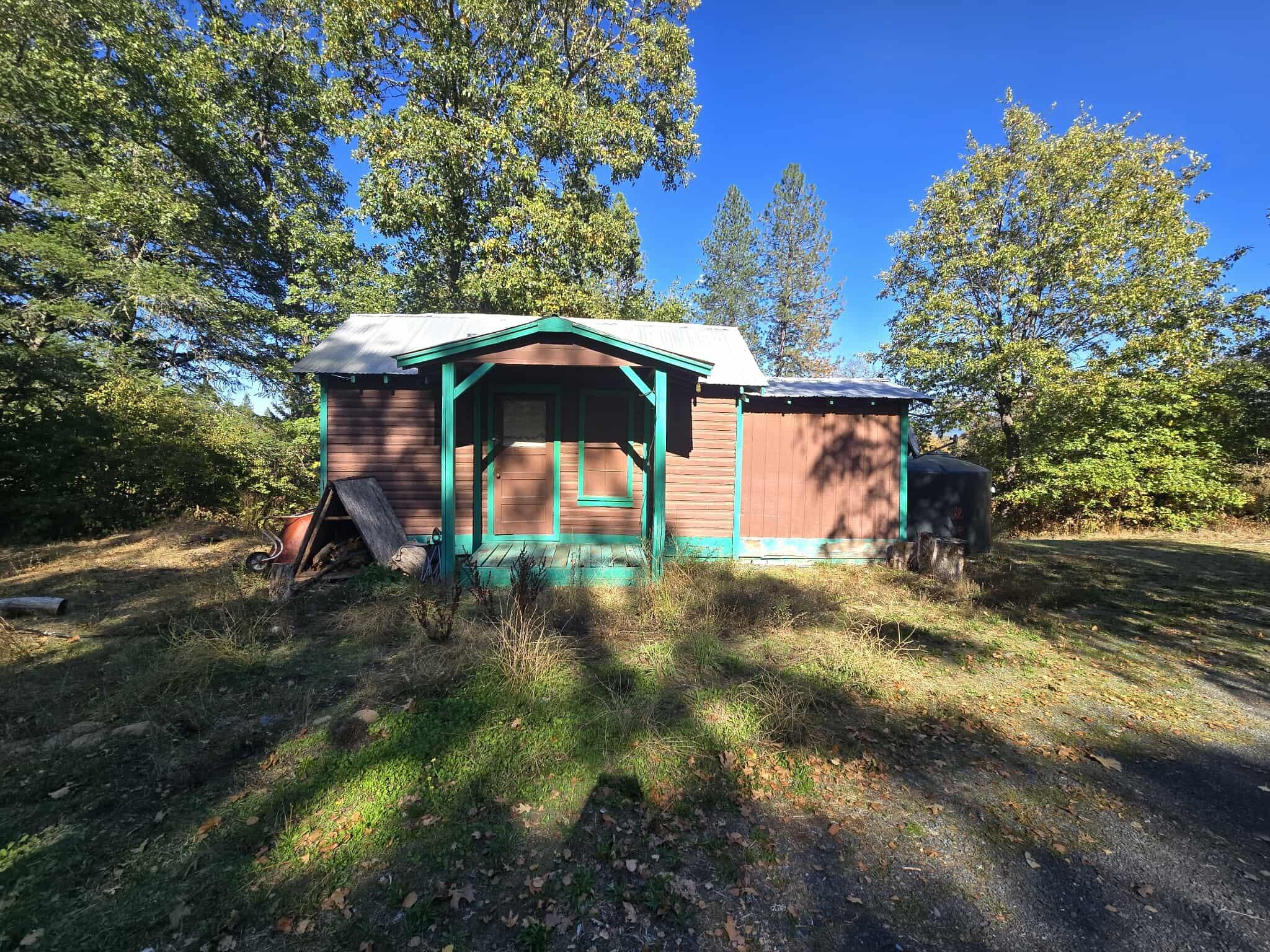 2565 Rockydale Road Cave Junction, OR 97523 - Photo 2 of 14 a view of a wooden house with a yard