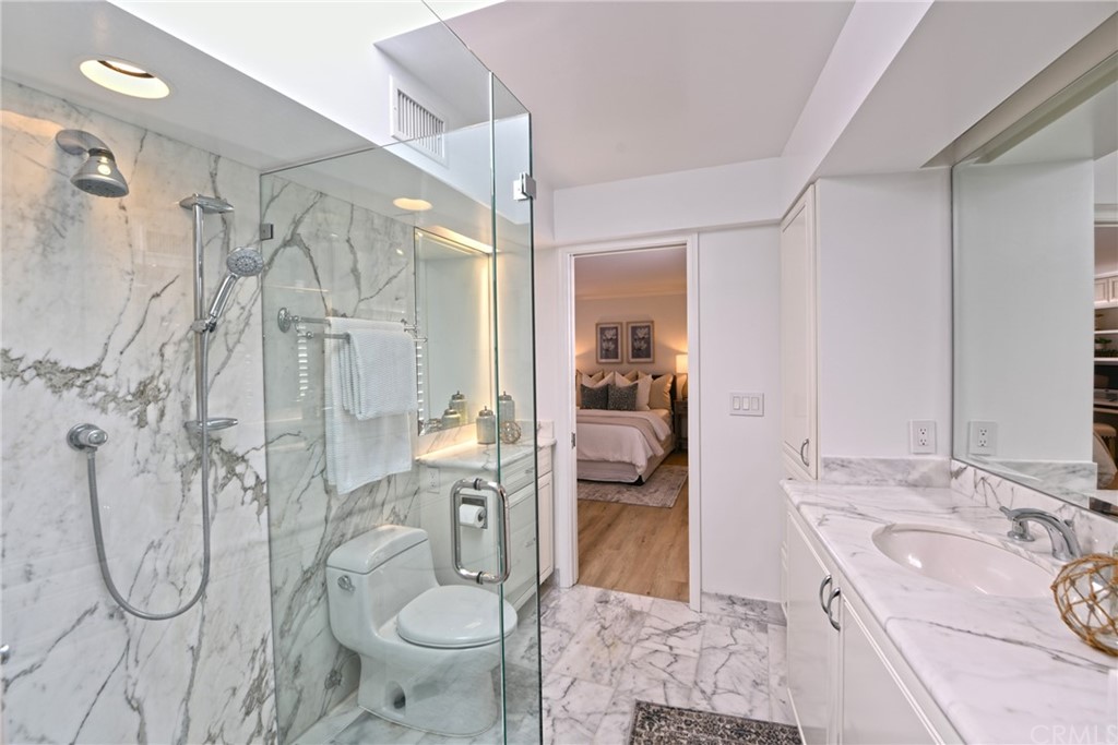 267 Avenida Lobeiro, Unit E San Clemente, CA 92672 - Photo 24 of 56 a bathroom with a granite countertop sink a toilet and shower
