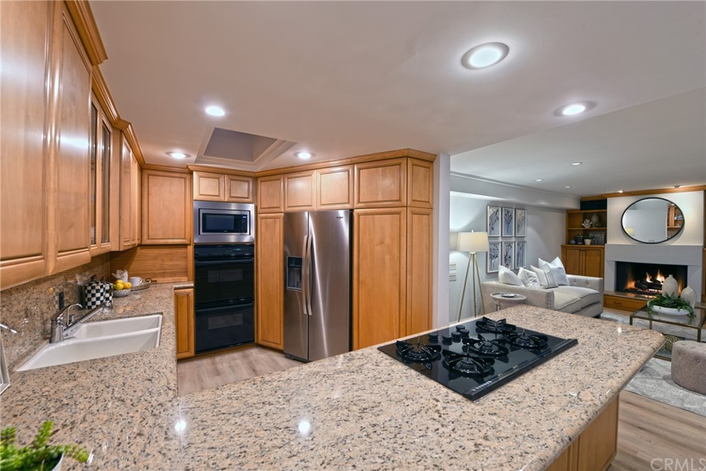 267 Avenida Lobeiro, Unit E San Clemente, CA 92672 - Photo 34 of 56 a kitchen with stainless steel appliances kitchen island granite countertop a refrigerator and a stove