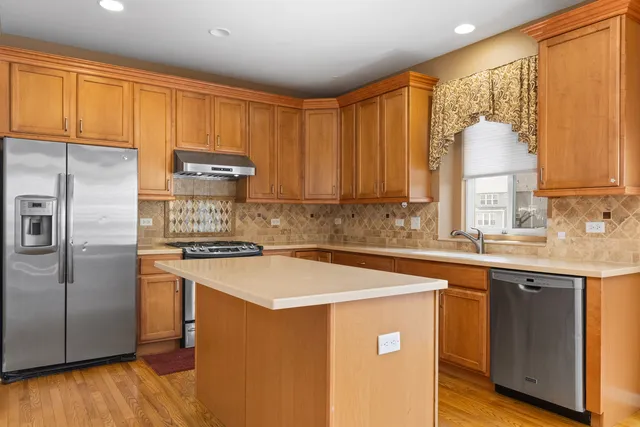a kitchen with stainless steel appliances granite countertop a stove a sink dishwasher and a refrigerator
