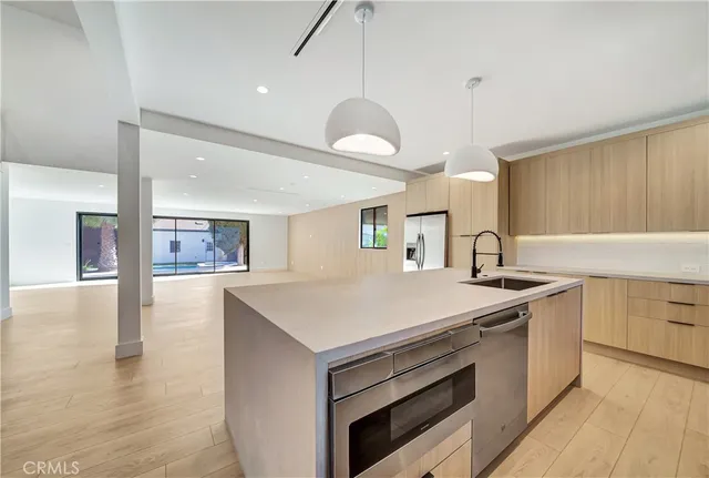 a kitchen with stainless steel appliances a stove a sink and a refrigerator