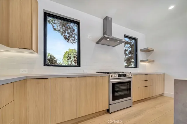 a kitchen with a sink a stove and a refrigerator with wooden floor