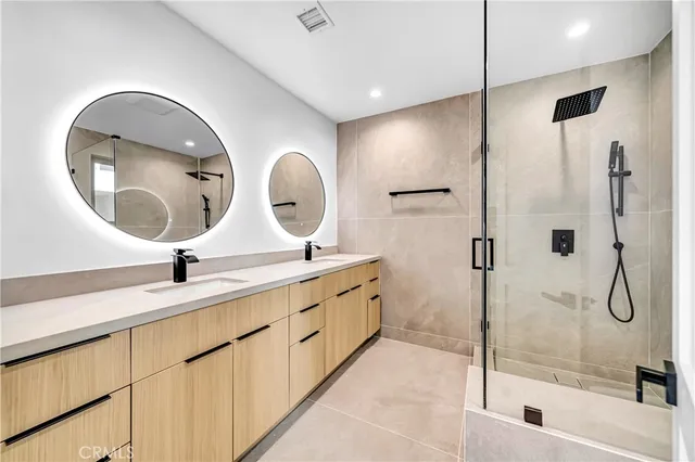 a bathroom with a double vanity sink mirror and shower