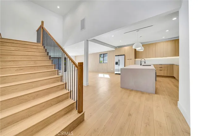 a view of a living room a kitchen with a sink and dishwasher stove refrigerator with wooden floor