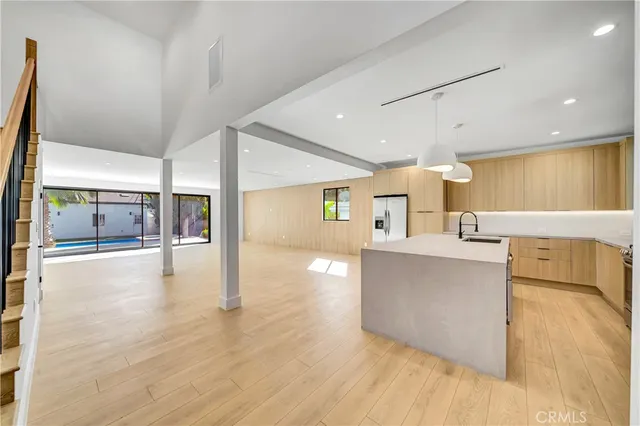 a view of an empty room with stairs and a window