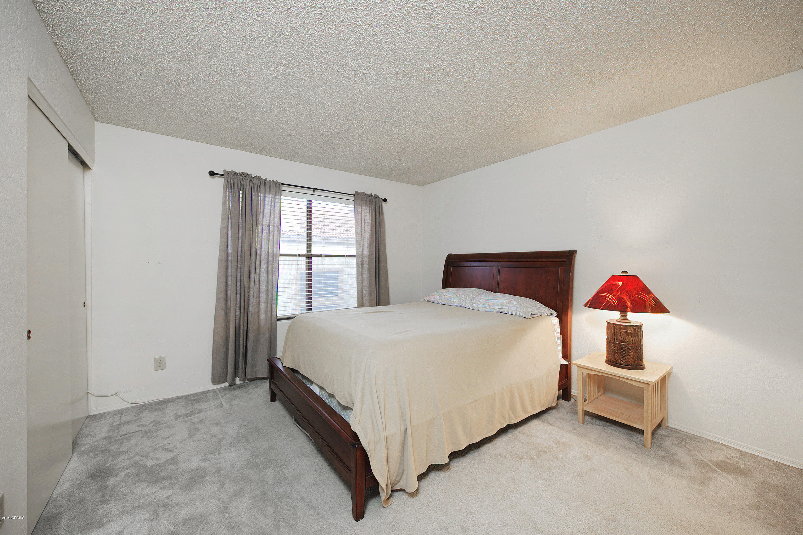 4217 East Agave Road Phoenix, AZ 85044 - Photo 16 of 20 a bedroom with a bed and window