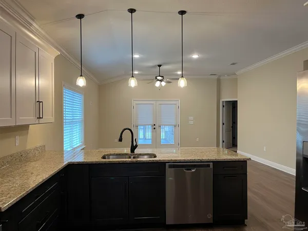 a kitchen with kitchen island granite countertop stainless steel appliances a sink cabinets a sink and a counter top